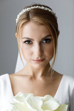 Düğün makyajı ve yatak odasında saç stili olan güzel bir gelin. Peçeli güzel bir gelin portresi. Genç ve güzel gelinin yakın plan portresi. Düğün..