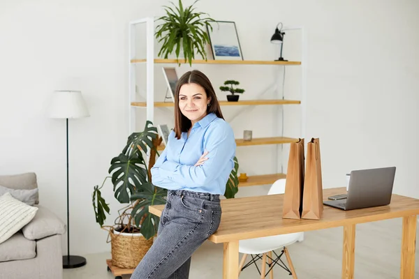 Sakin ve huzurlu genç bir kadın mola verir, ofisteki masanın yanında bir fincan sıcak içecekle dinlenir..