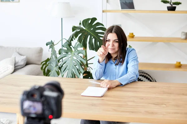Samimi Oturma Odasında Masada Oturan Güzel Kadın ve Dizüstü bilgisayardaki Video Okul Dersini İzleyen Kadın. Uzaktan Öğrenci Çalışması. Sosyal ağda Arkadaşlarla Sohbet.