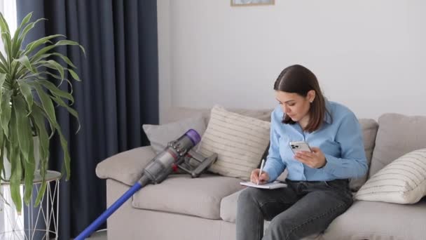 Ung Vacker Kvinna Sitter Soffan Arbetar Med Mobiltelefon Och Gör — Stockvideo