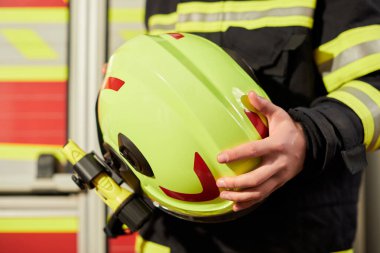 Close up image of a firefighter's helmet. Firefighter holding a yellow helmet