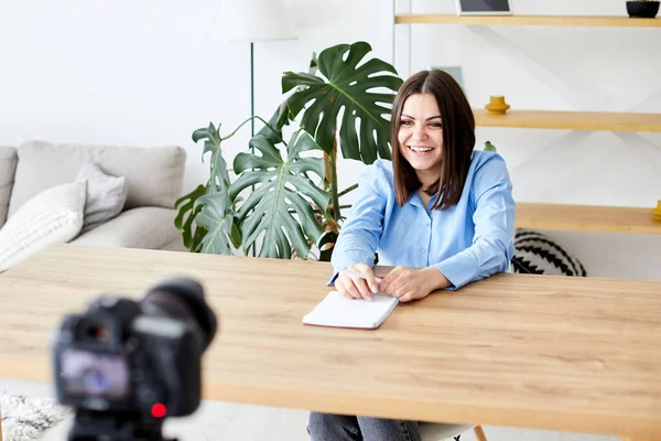 Samimi Oturma Odasında Masada Oturan Güzel Kadın ve Dizüstü bilgisayardaki Video Okul Dersini İzleyen Kadın. Uzaktan Öğrenci Çalışması. Sosyal ağda Arkadaşlarla Sohbet.