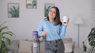 Büyüleyici esmer ev hanımı modern süpürgeyle halıyı temizlerken evde eğleniyor. Oda servisi kavramı.