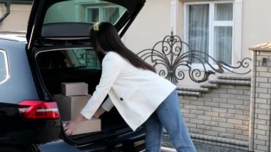 Genç bir iş kadını bir araba bagajından paketler alıyor, arabayla eve geliyor. İnternetten mal alıp eve teslim etme kavramı