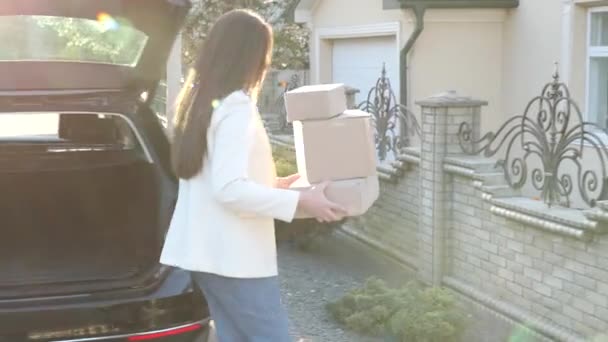 配達の概念 女の子は家の近くに立っていて 手に箱を持ち カメラの前に1つの箱を持っています — ストック動画