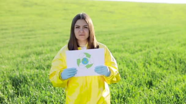 身着工作服的人拿着纸 一边喊着要在日落时分站在绿地上拯救地球 一边表示要停止污染地球 — 图库视频影像