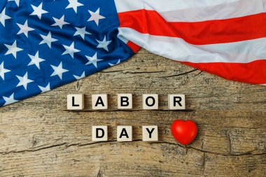 US American flag with wooden cubes with word Labor day on old wooden background. Labor day celebration. 