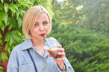 Şık genç sarışın şehirde dolaşıyor ve soğuk bir şeyler içiyor. İşten sonra harcanan zaman