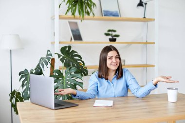 Laptop ekranına bakan neşeli genç bir kadın, evdeki iyi haberler için heyecanlanıyor..