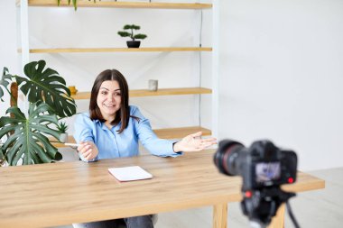 Samimi Oturma Odasında Masada Oturan Güzel Kadın ve Dizüstü bilgisayardaki Video Okul Dersini İzleyen Kadın. Uzaktan Öğrenci Çalışması. Sosyal ağda Arkadaşlarla Sohbet.