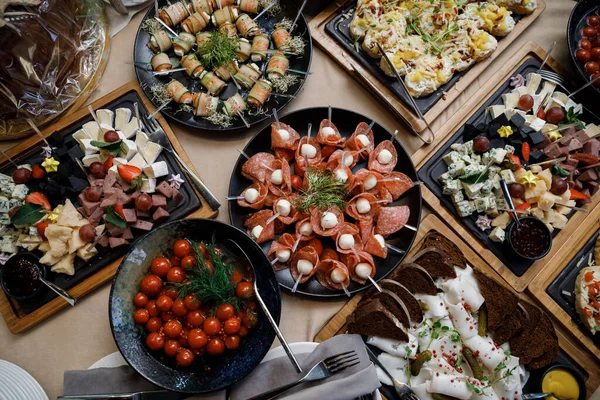 Buffet table with food and snacks for the guests of the event. Service at business meetings, weddings. Full table of appetizers