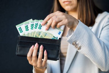 Avro banknotları ile siyah cüzdan tutan genç bir iş kadını, nakit para ile kadın ellerini kapatın..