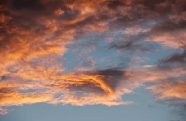 Dönen akşam bulutları batan güneşle aydınlanıyor.