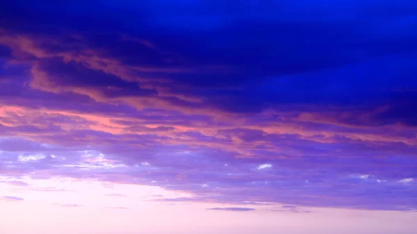 Dönen akşam bulutları batan güneşle aydınlanıyor.