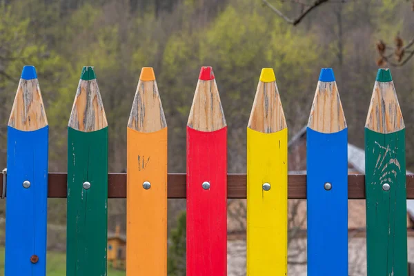 Keskinleştirilmiş boya kalemleri veya kalemleri andıran renkli ahşap çitler.