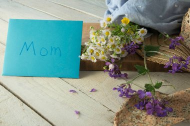 Annemi kutluyoruz. Kumaşa sarılmış kır çiçeği buketi..