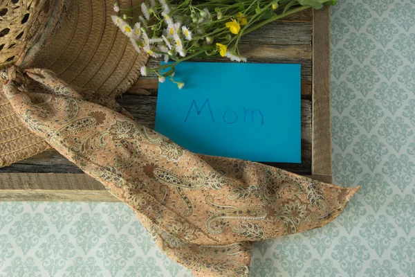 Tahta tepside taze koparılmış bir buket kır çiçeğiyle çocuk tarafından yazılmış bir anne kartı. Anneler Günü. Doğum günü. 