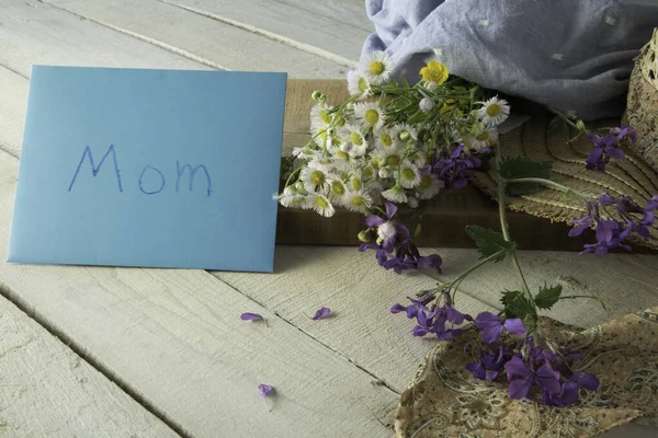 Annemi kutluyoruz. Kumaşa sarılmış kır çiçeği buketi..