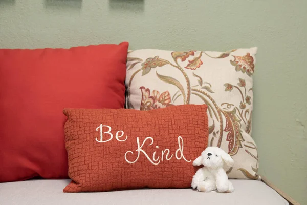 Be kind statement on a bench with a plush animal.  School office interior.