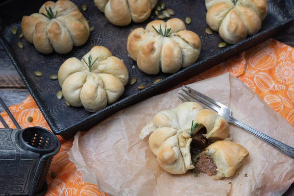 First bite of fresh baked pumpkin shaped biscuits stuffed with fresh parmesan cheese, basil pesto, spicy Italian meatballs.