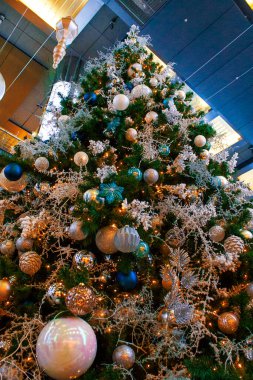 Renkli süslemeleri, çelenkleri ve ışıkları olan bir Noel ağacının yakın fotoğrafını çek..