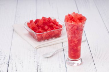 Karpuz dilimleri, şeffaf bir cam ve kare bir kasede yerleştirilmiş karpuz dilimleri, kırsal beyaz arka planda izole edilmiş..