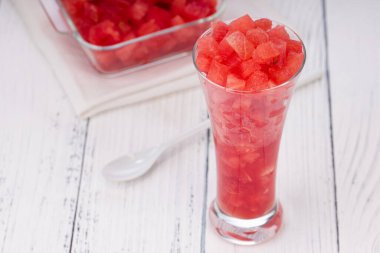 Karpuz dilimleri, şeffaf bir cam ve kare bir kasede yerleştirilmiş karpuz dilimleri, kırsal beyaz arka planda izole edilmiş..