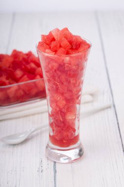 Karpuz dilimleri, şeffaf bir cam ve kare bir kasede yerleştirilmiş karpuz dilimleri, kırsal beyaz arka planda izole edilmiş..