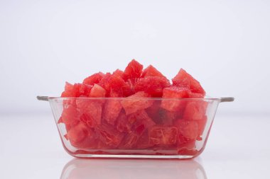 Karpuz dilimleri, şeffaf kare cam bir kasede sıralanmış karpuz dilimleri, beyaz kırsal arka plan, izole edilmiş..