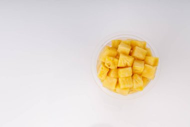 Beyaz arkaplanlı şeffaf camlarda sıralanmış ananas küpleri