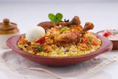 Chicken biryani , Kerala style chicken dum biriyani made using jeera rice and spices arranged in  earthen ware  on white background, isolated clipart