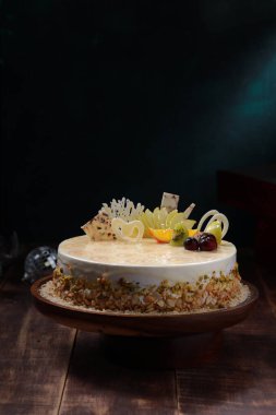 Beyaz çikolatalı pasta, ahşap bir arka planda düzenlenmiş.