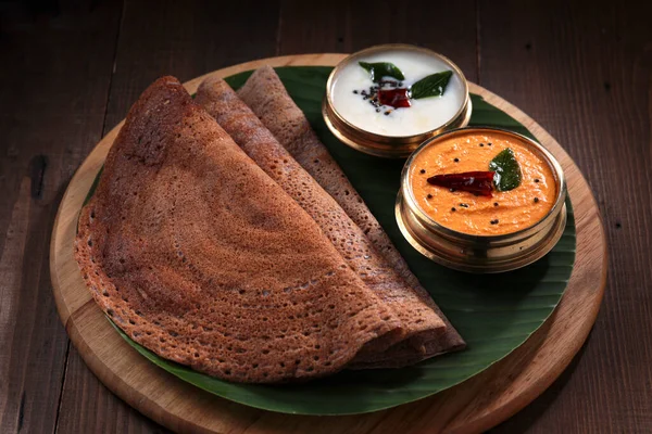 Ragi Dosa 南印度人健康的早餐用品 摆放在一个圆形木制底座上 旁边排列着香蕉叶和椰子胡桃 — 图库照片