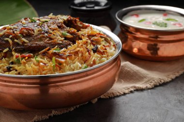 Balık Biryani, Güney Hindistan usulü balık biryani geleneksel olarak yanında raitha olan pirinç bir kaba yerleştirilir..