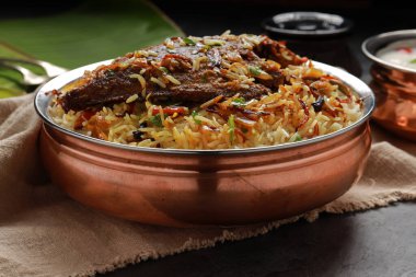 Balık Biryani, Güney Hindistan usulü balık biryani geleneksel olarak yanında raitha olan pirinç bir kaba yerleştirilir..
