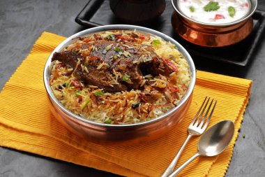 Balık Biryani, Güney Hindistan usulü balık biryani geleneksel olarak yanında raitha olan pirinç bir kaba yerleştirilir..