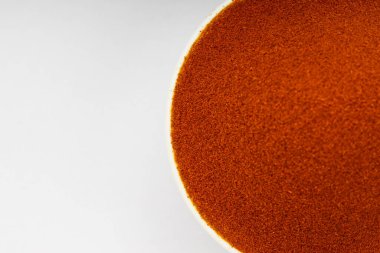 Kırmızı biber tozu, Hint baharatı; beyaz desenli ya da arka planlı beyaz bir kâsede dizilmiş.