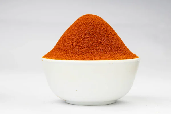 Red chilly powder ,Indian spice;arranged in a white bowl  with white texture or background