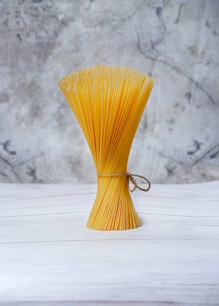 Beyaz arka planda makarna bağlanmış halat.