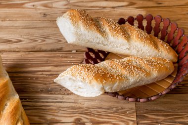 Ekmek ekmeği üzerine susam serpiştirilmiş Tahta masa üzerinde ambalaj kağıdı