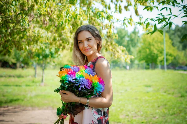 En ung flicka med blommor på bakgrunden av en grön skog — Stockfoto