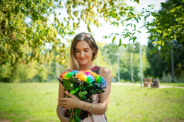 Una joven con flores en el fondo de un bosque verde — Foto de Stock