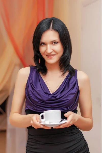 Bir kız elinde bir bardak tutuyor.