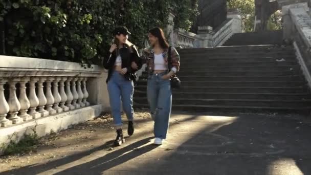 Zwei Junge Frauen Gehen Bei Sonnenuntergang Arm Arm Eine Treppe — Stockvideo