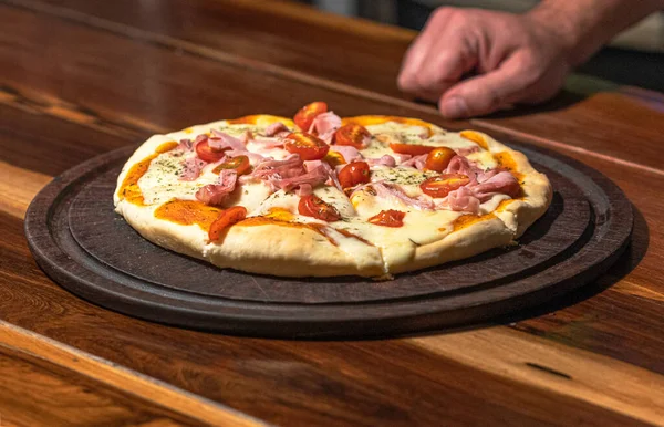 Domatesli, jambonlu ve mozarellalı ev yapımı pizza hazır.
