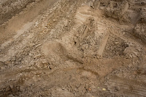 Wheel trail on sandy ground from large transport, tractor on construction site, sandy road