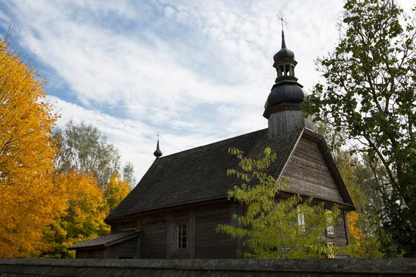 Paysage d'automne. Feuillage jaune sur les arbres et une église rustique en bois. — Photo