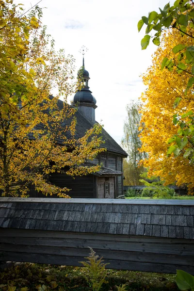 Sonbahar manzarası. Ağaçlarda sarı yapraklar ve kırsal ahşap bir kilise.. — Stok fotoğraf