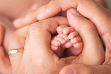 Sevgi dolu bir ebeveyn bebek bacakları tutar. Mutlu bir çocukluk. Ebeveyn bakımı. 