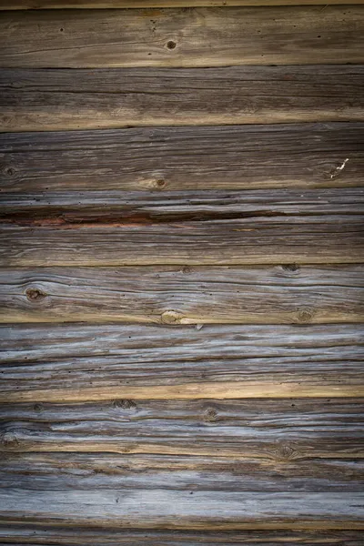 Drewniane kłody starego domu. Zbliżenie. Naturalna tekstura z szarego drewna. Kontekst. zdjęcie pionowe. — Zdjęcie stockowe